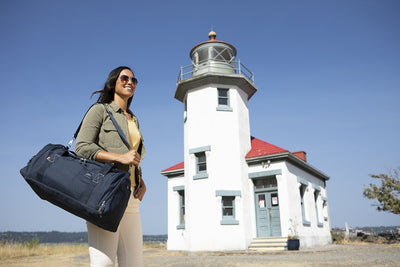 Woman carrying Whidbey duffel bag outside of Mukilteo Lighthouse in Washington state